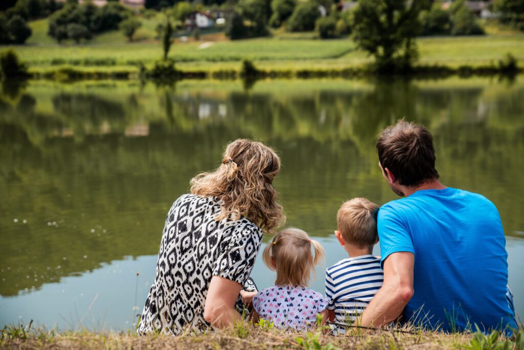 Družinsko fotografiranje ob reki – ujeti iskreni trenutki in nasmehi.